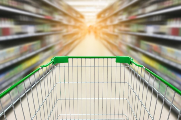 Shopping cart with blur background of wine bottles on liquor shelves in supermarket store