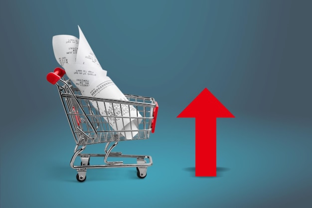 Shopping cart with cardboard boxes and red up arrow. Growth wholesale and retail.