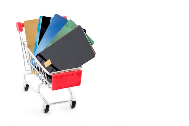 Shopping cart with credit cards on white background. Copyspace for text.