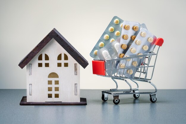 Shopping cart with different pills blister pack and house model Concept of buying drug deliveryxDxA