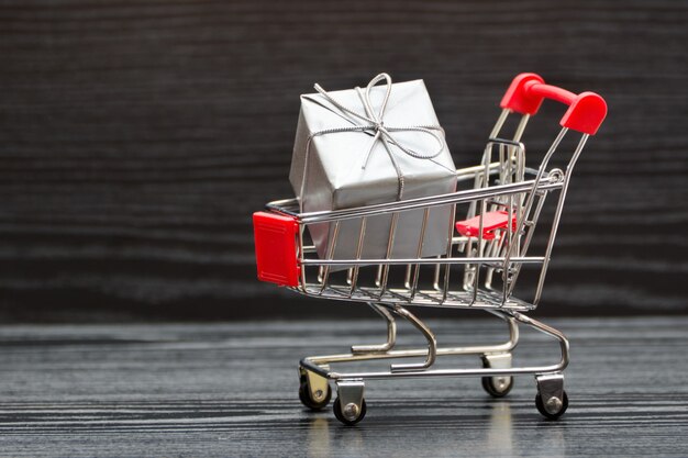 Shopping cart with gift boxes. Holiday sale