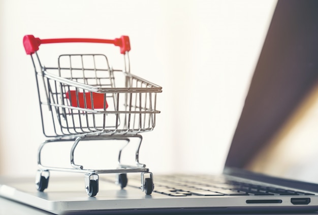 Photo shopping cart with laptop on the desk