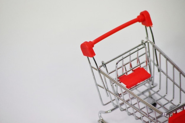 A shopping cart with a red handle