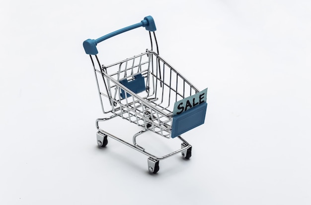 Shopping cart with sale inscription on white background