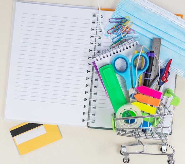 Shopping cart with school supplies protective mask alcohol gel Back to school during a covid19