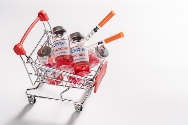 shopping cart with vaccine vials bottles and syringes for COVID-19 vaccination