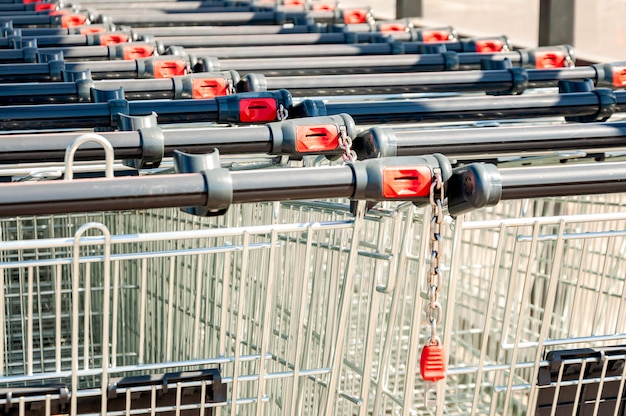 Carrelli della spesa nel negozio, assemblati in fila nel parcheggio. avvicinamento.