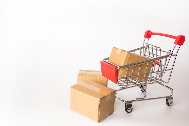 Shopping concept : Cartons or Paper boxes in red shopping cart on white background. 