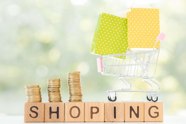 Shopping concept Closeup Isolated shopping trolley stack coins and word shopping