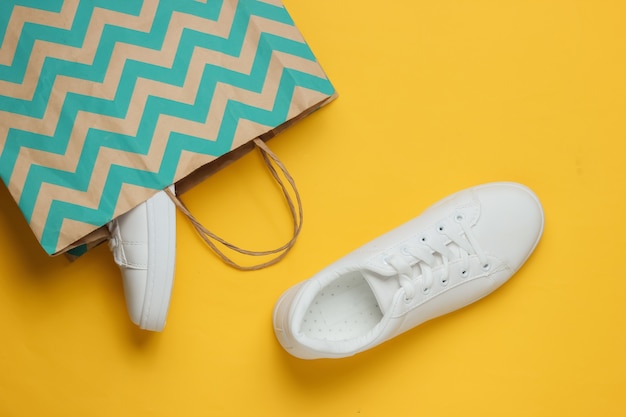 Shopping concept Fashion studio shot White sneakers in paper bag for shopping