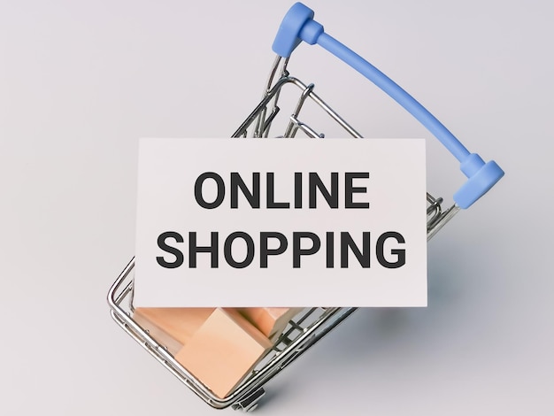 Foto shopping concept phrase online shopping op witte kaart met trolley vol houten kubussen