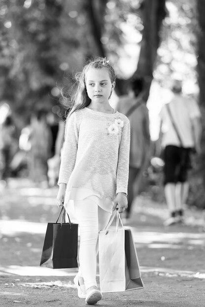 Shopping concept Pretty little girl walking with the pink shopping bags