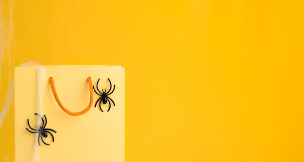 Shopping and discounts on halloween shopping bag with black
spiders on a bright orange background