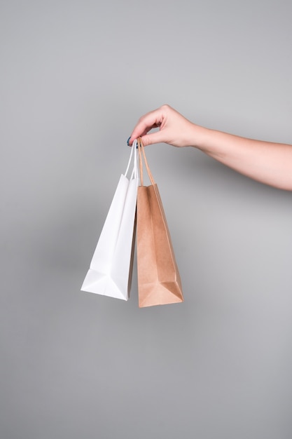 Shopping e sacchetti regalo in carta kraft su una parete grigia. concetto di rifiuti zero