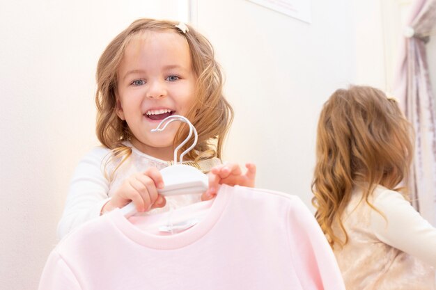 Shopping. A girl trying on a beautiful dress gently pink in the fitting room of the boutique.