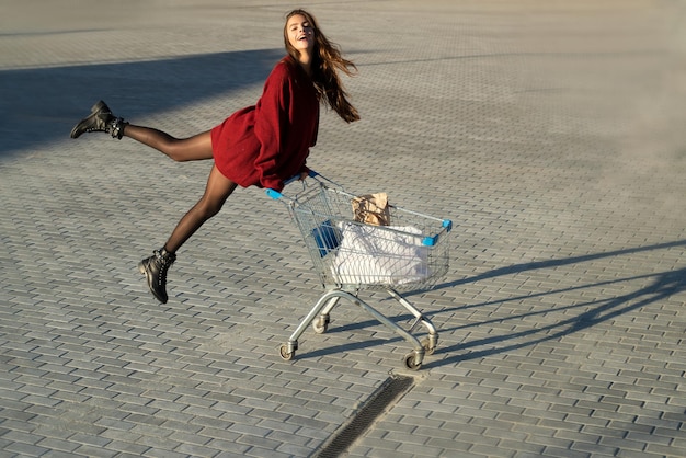 Shopping girl with shop cart. Marketing concept.