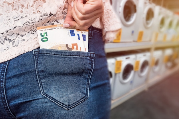 Shopping in home appliance store, euro banknotes in pocket