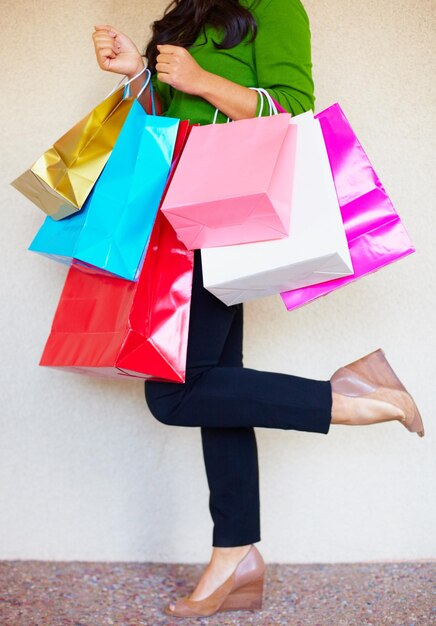 Photo shopping legs and bags with a woman customer in studio on a white background for retail consumerism fashion sale and shoes with a female consumer at a mall store or luxury market as a shopper