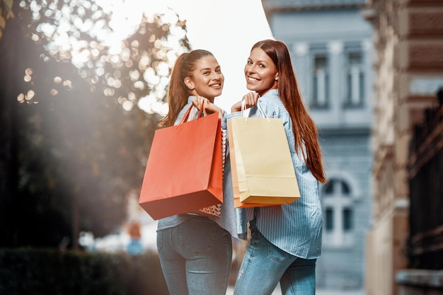 Shopping Mania Two young women are happy after shopping Smiling and walking down the street