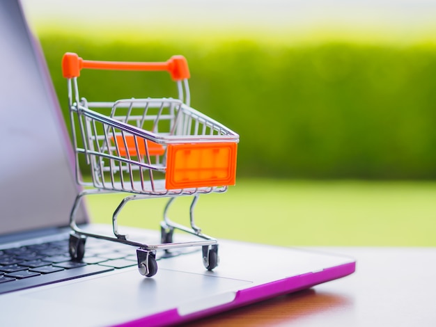 Shopping Online Concept : Mini Shopping Cart On Laptop.