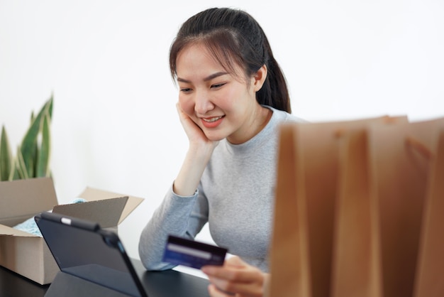 Concetto di shopping online una giovane donna che utilizza la sua carta di credito per facilitare un acquisto online nell'applicazione di shopping online.