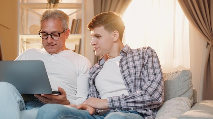 Shopping online family generation internet leisure happy father and son surfing on laptop together