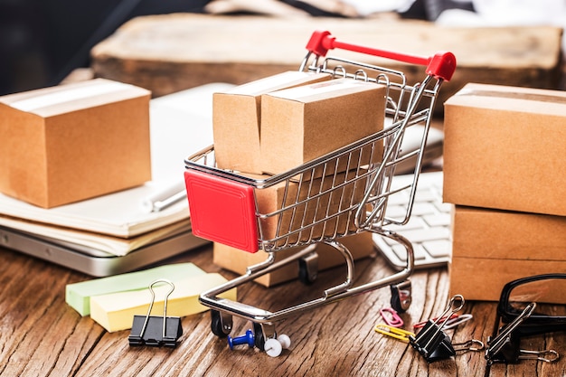 Shopping online at home concept. Cartons in a shopping cart on a laptop keyboard.