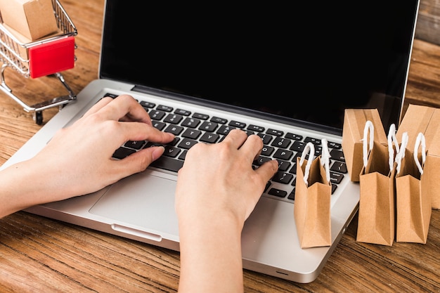 Shopping online at home concept. Cartons in a shopping cart on a laptop keyboard.