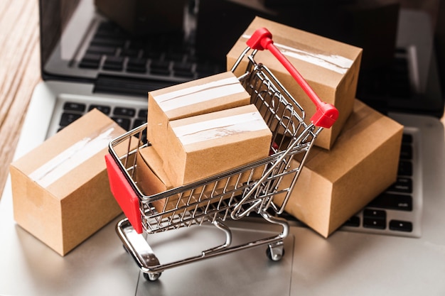 Shopping online at home concept.Cartons in a shopping cart on a laptop keyboard