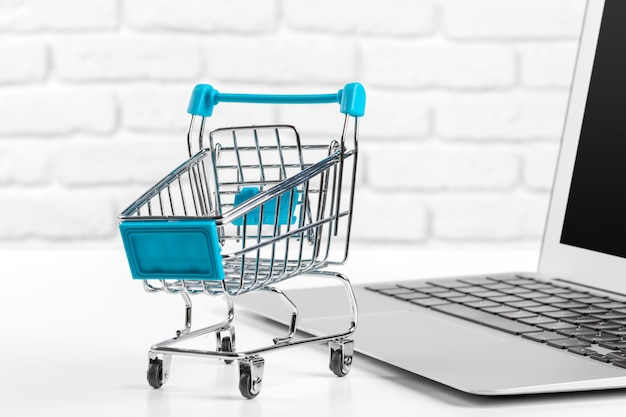 Shopping Online   Mini Shopping Cart and Laptop