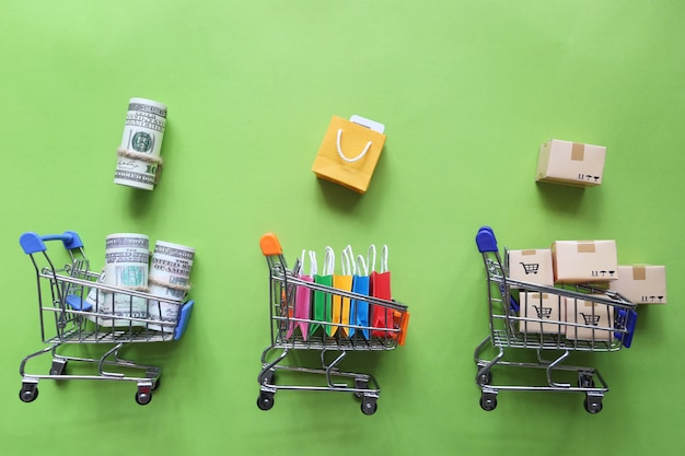 Shopping online, Paper shopping bag and banknote, brown parcel box on model miniature cart on colorful background