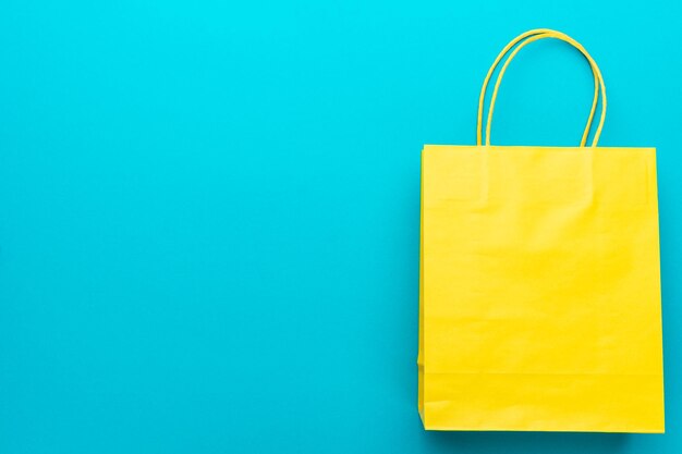 Shopping paper bag on blue background with copy space summer sale concept