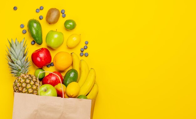 Shopping paper bag full of healthy food on yellow