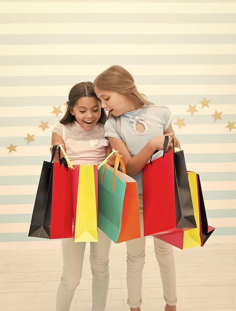 Shopping the place for fun Cute little shoppers Adorable girls looking into shopping bags Small children enjoy shopping Shopping for real life