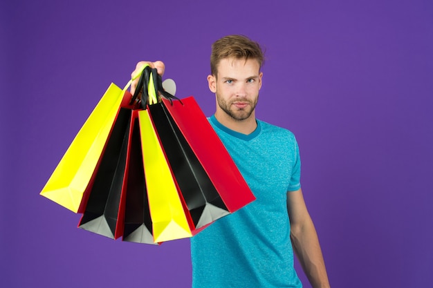 Shopping or sale and cyber monday Man with shopping bags on violet background Macho