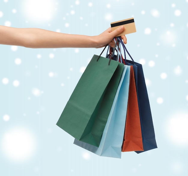 покупки, распродажа, подарки, рождество, рождественская концепция - женщина с хозяйственными сумками и кредитной картой