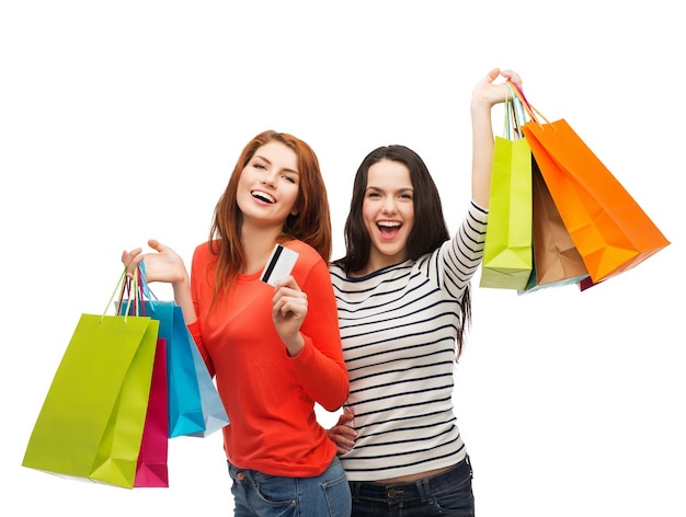 쇼핑, 판매, 선물 개념 - 쇼핑백과 신용카드를 들고 웃고 있는 10대 소녀 2명