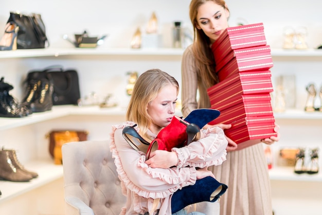 Shopping In the shoe department One of the two girls holds boxes with shoes