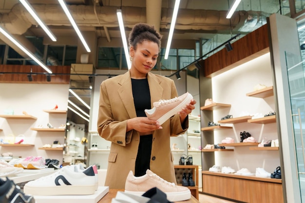 Foto shopping in negozio una giovane donna sceglie scarpe nuove