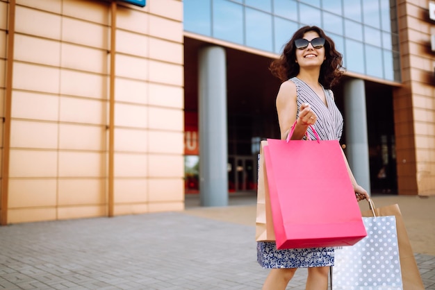 ショッピングの時間 ショップの近くでショッピングバッグを持った若い女性 消費者向けの売り上げ買い物