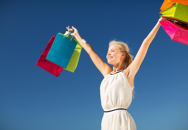 shopping and tourism concept - woman with shopping bags