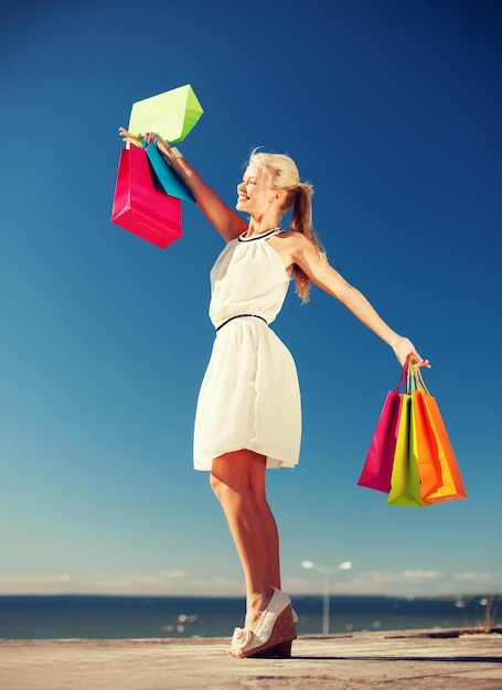 shopping and tourism concept - woman with shopping bags