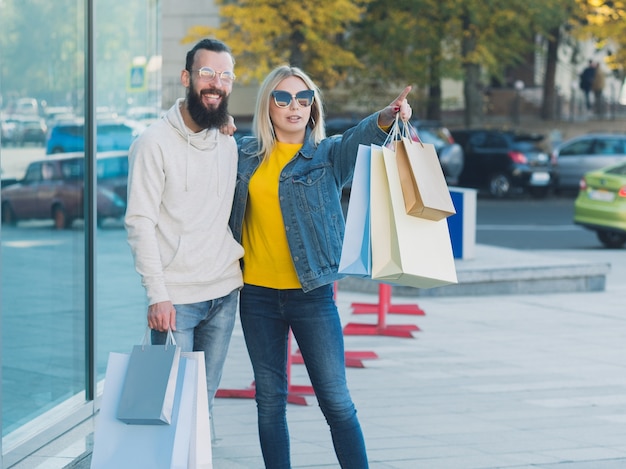 Shopping tourism. Couple walking with packages in city center.