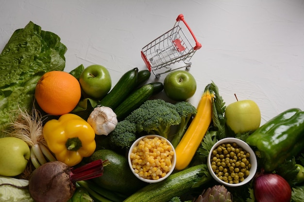 Foto carrello della spesa carrello e diversi tipi di frutta e verdura fresca per il layout assortimento di frutta e verdura fresca sfondo di cibo sano shopping cibo nel supermercato