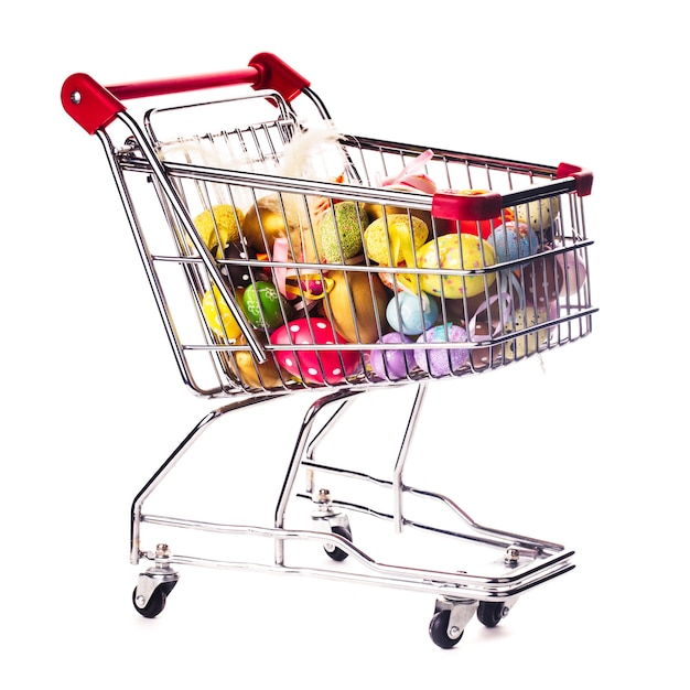 Shopping trolley with many decorative easter eggs on white