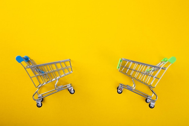 Shopping trolley on yellow background