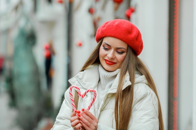 ショッピング。クリスマスのロリポップを保持している若い女性。休日。