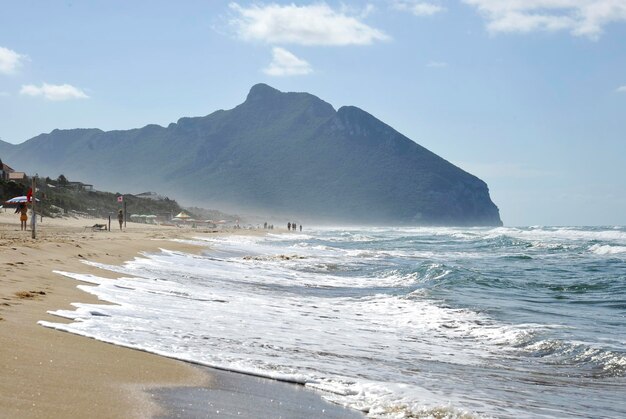 Shoreline under a cloudy sky in the background the famous Circeo mountain Lazio Italy