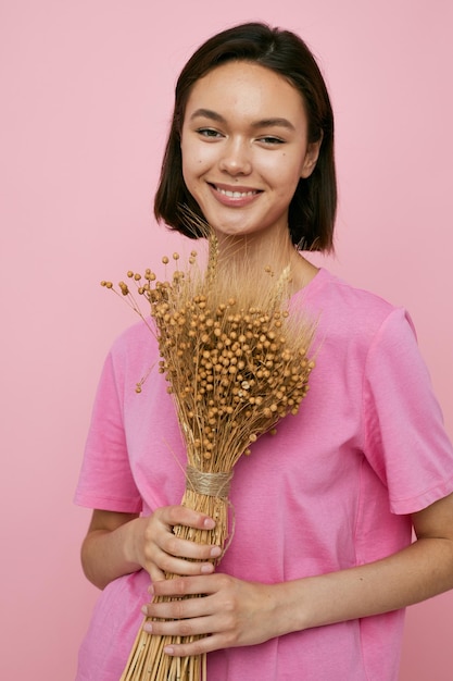 Short haired brunette a bouquet of dried flowers pink tshirt Lifestyle unaltered