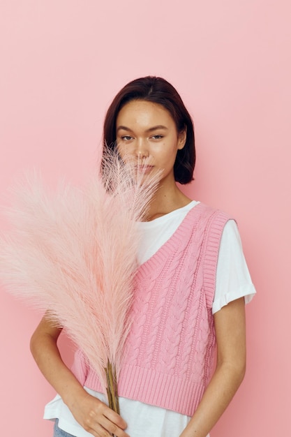 Short haired brunette pink feathers in hand posing casual wear Lifestyle unaltered